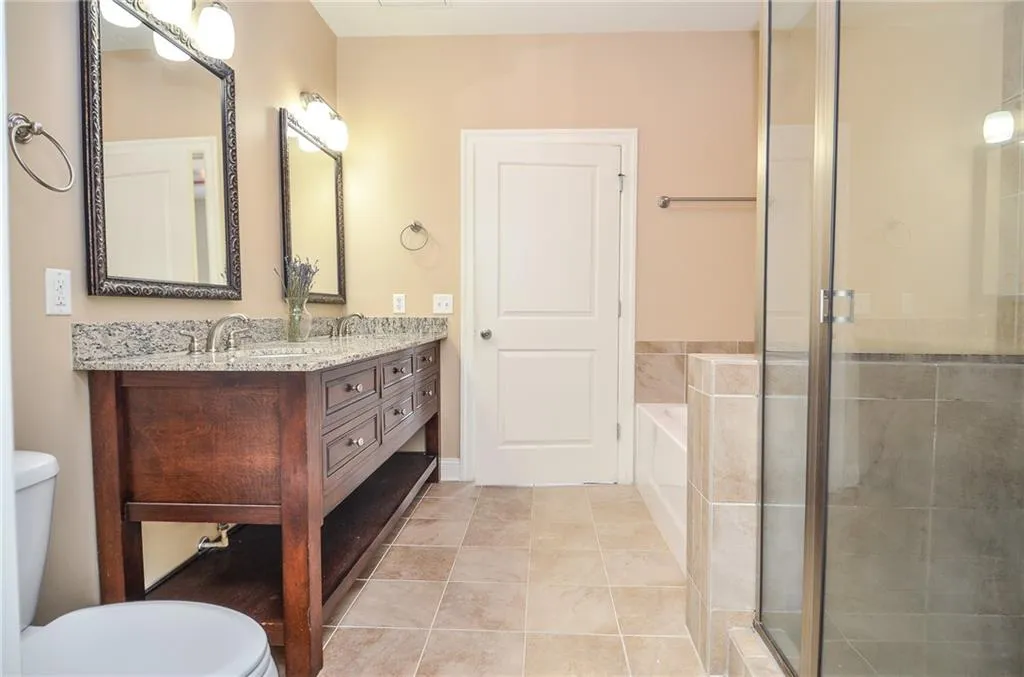 Full bathroom featuring tile patterned flooring, separate shower and tub, vanity, and toilet