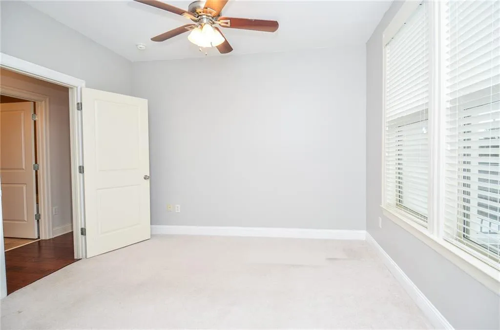 Unfurnished bedroom with light hardwood / wood-style floors, ceiling fan, and multiple windows