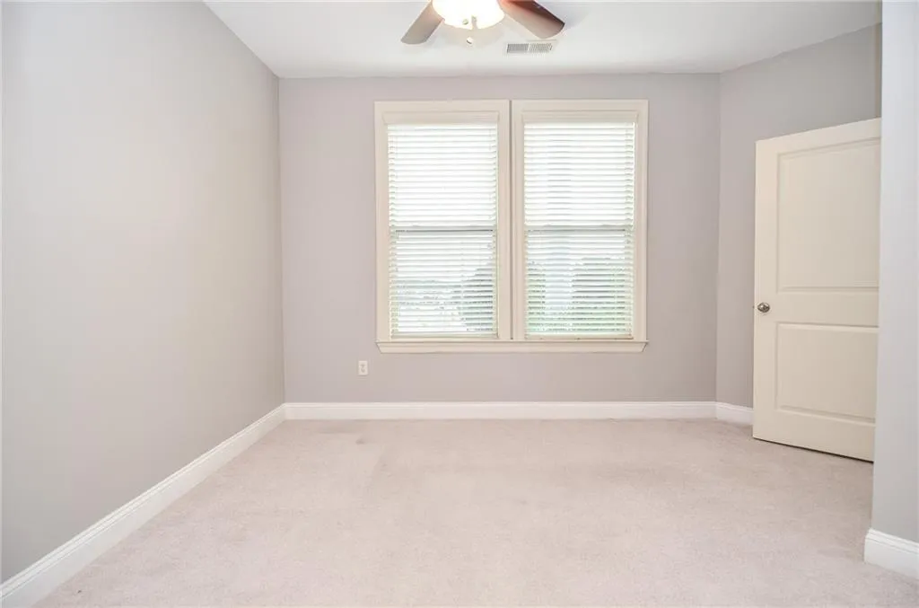Unfurnished room with light carpet and ceiling fan