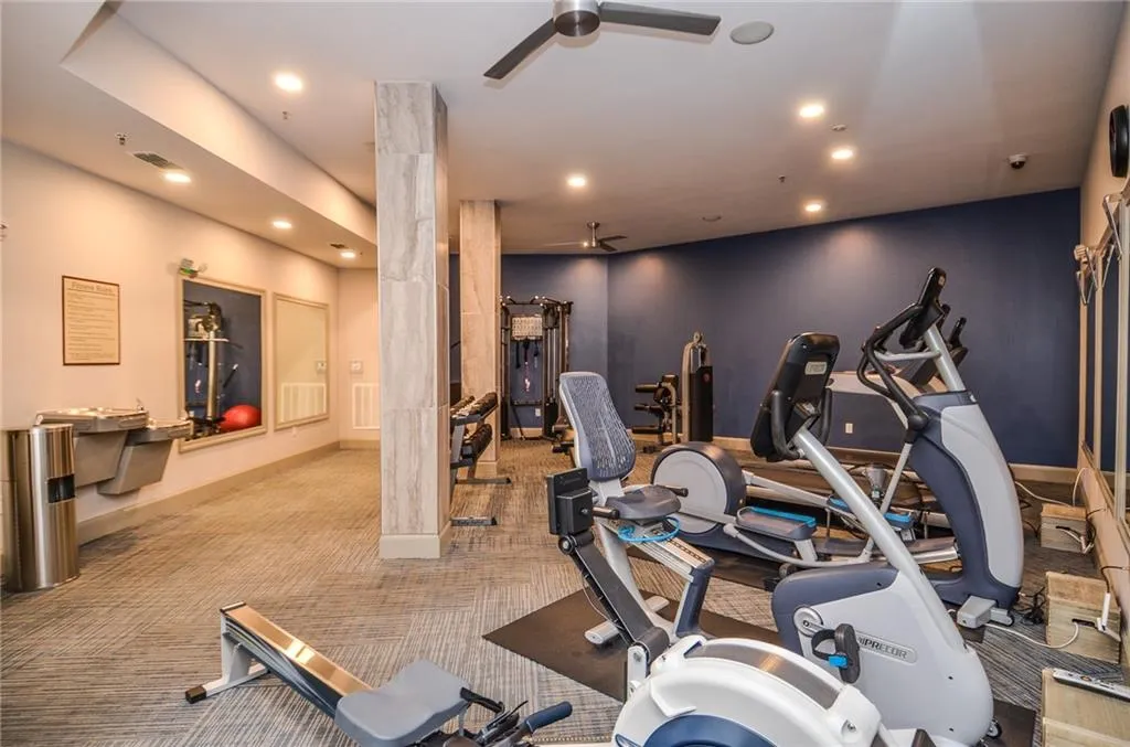 Workout area featuring light carpet and ornate columns