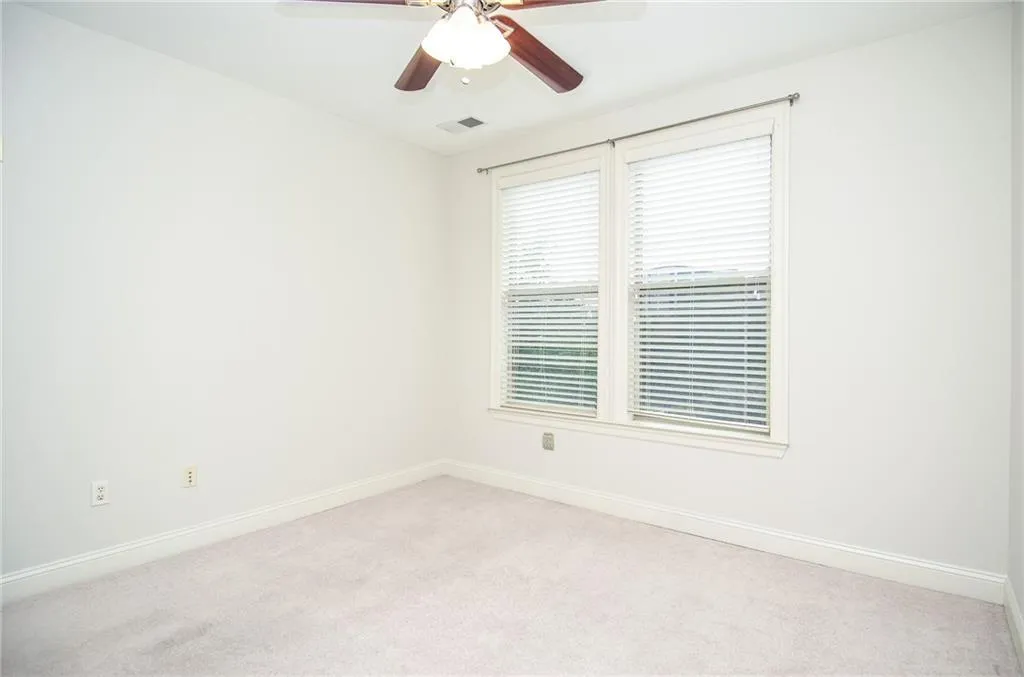 Carpeted empty room with ceiling fan