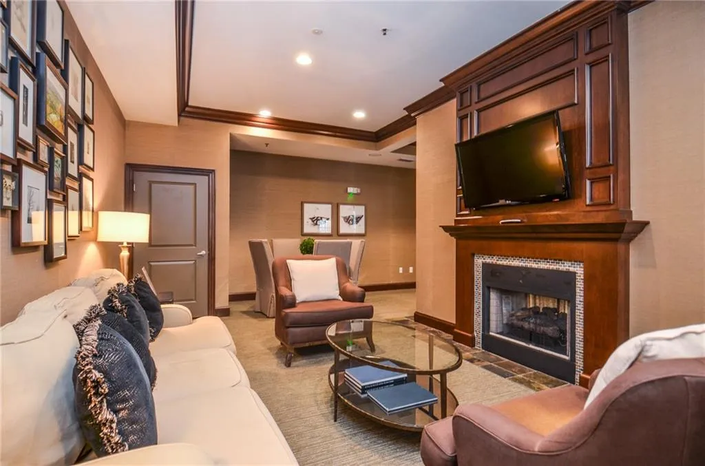 Carpeted living room featuring crown molding and a tiled fireplace