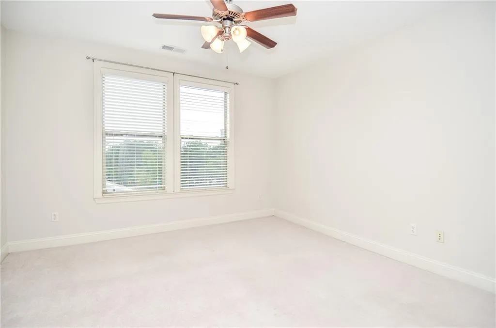 Carpeted empty room with ceiling fan