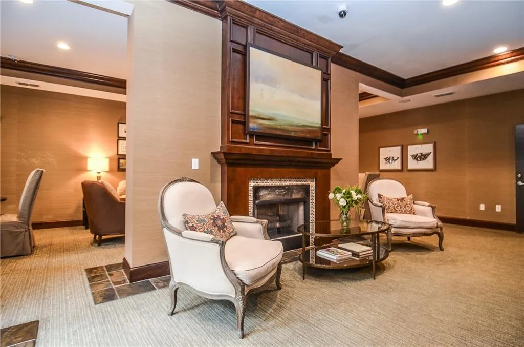 Living area featuring ornamental molding, carpet floors, and a fireplace