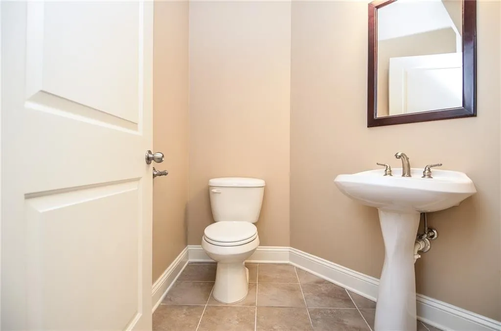 Bathroom with tile patterned flooring, toilet, and sink
