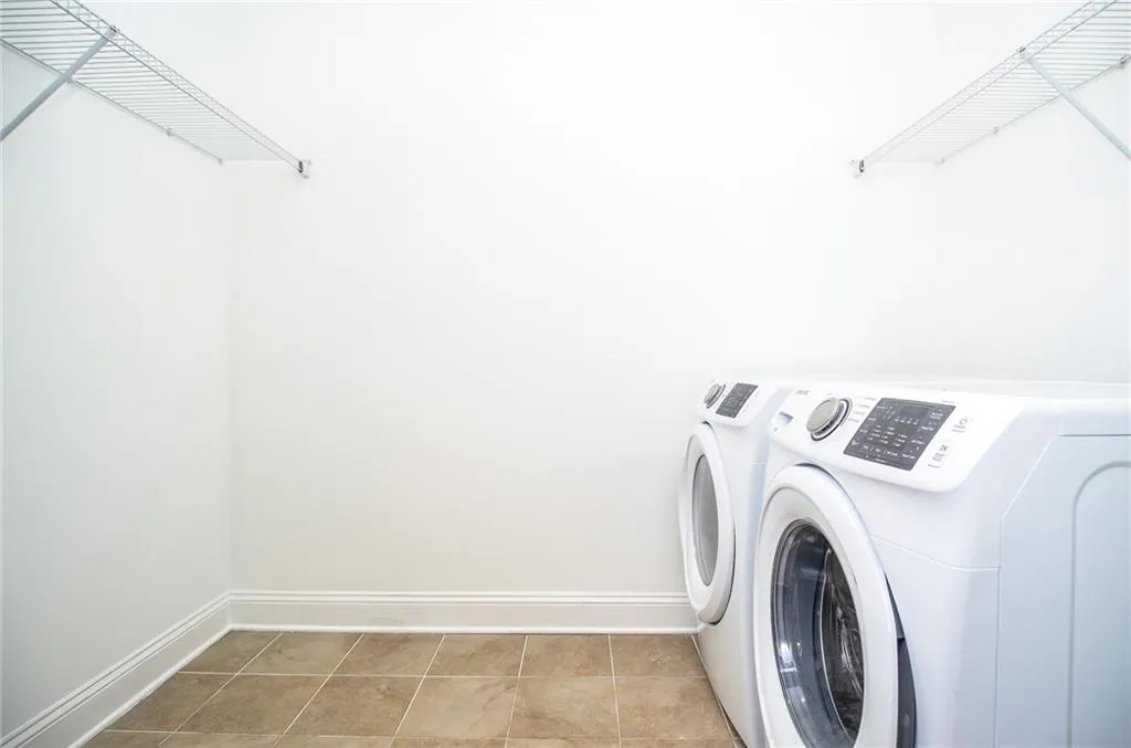 Washroom featuring light tile patterned floors and washer and dryer