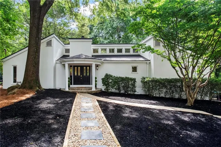 White stucco exterior with a prominent covered entry