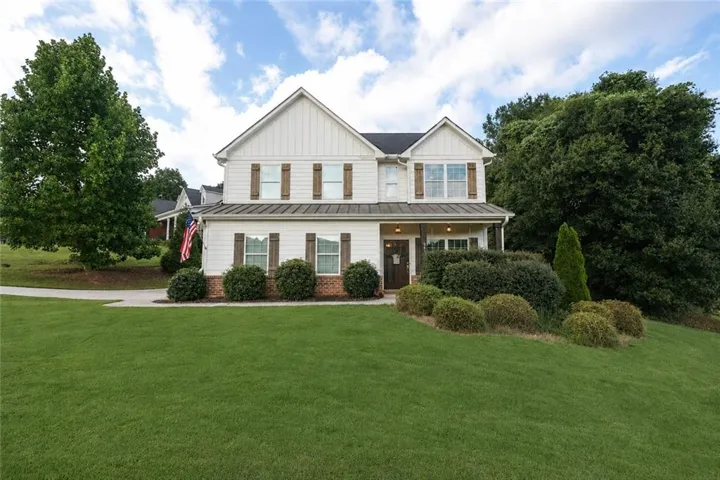 Two-story residence with white siding and brick accents