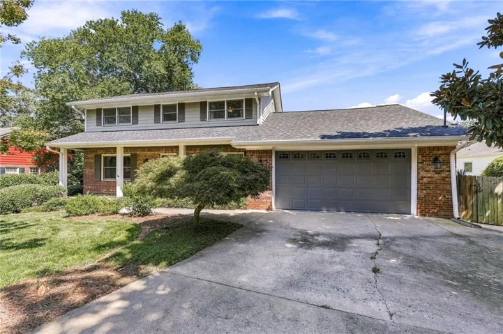 Brick and siding exterior with a covered front porch and a two-car garage