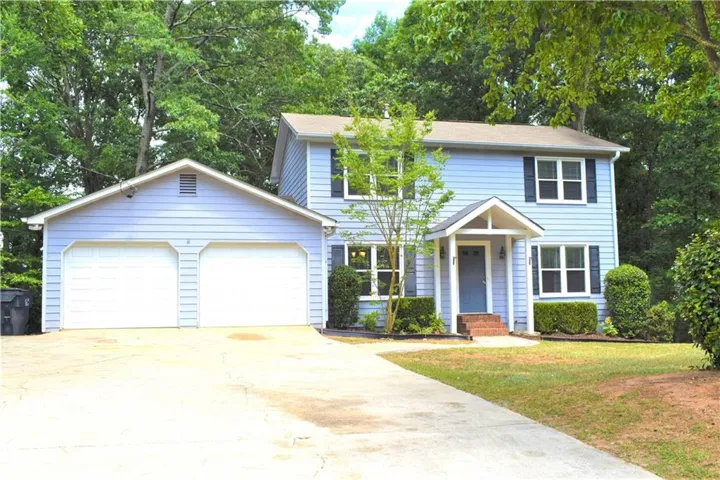 Two-story residence with light blue siding and dark window shutters