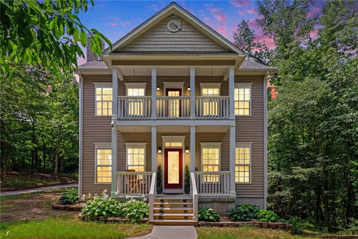 Two-story residence featuring a covered front porch and a second-story balcony