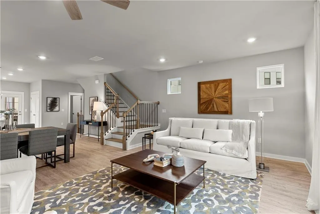 Living area featuring stairs, recessed lighting, light wood-style flooring, and a ceiling fan