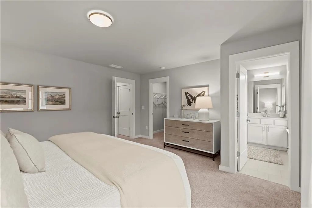 Bedroom featuring light colored carpet, a walk in closet, ensuite bath, and light tile patterned flooring