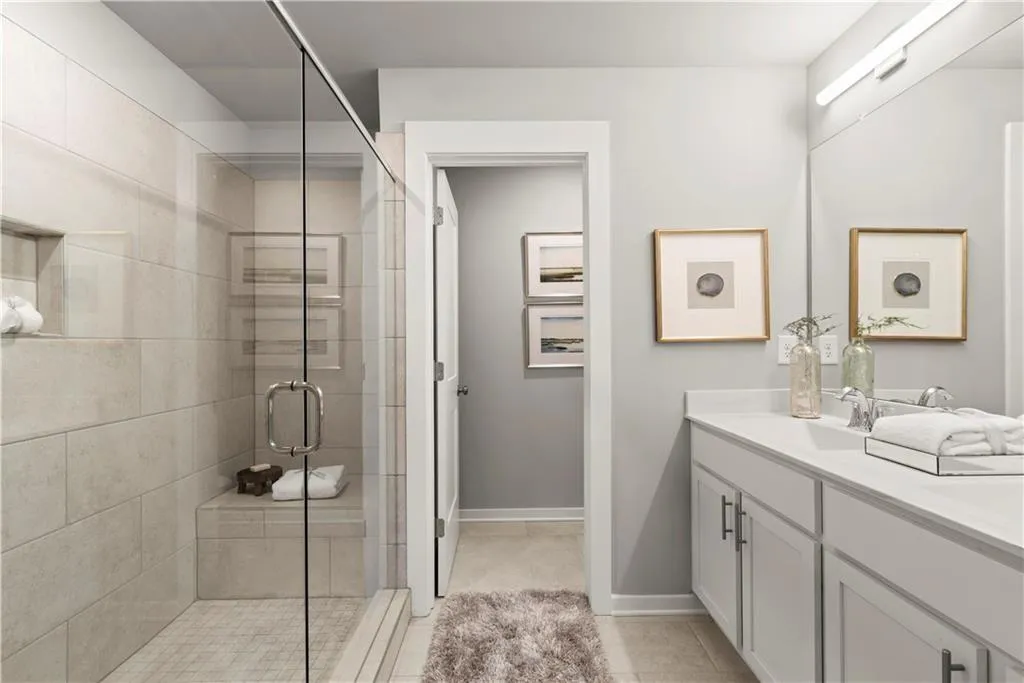 Bathroom with double vanity, a shower stall, and light tile patterned flooring