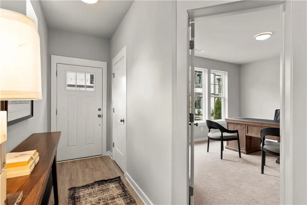 Foyer with baseboards and light carpet