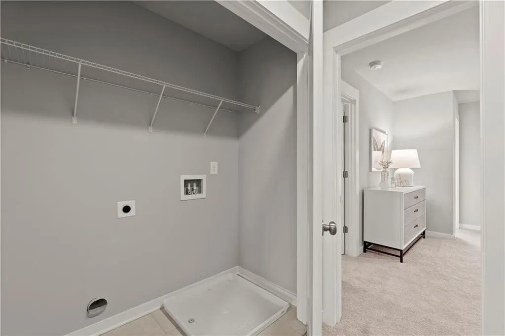 Laundry area with washer hookup, hookup for an electric dryer, and light colored carpet