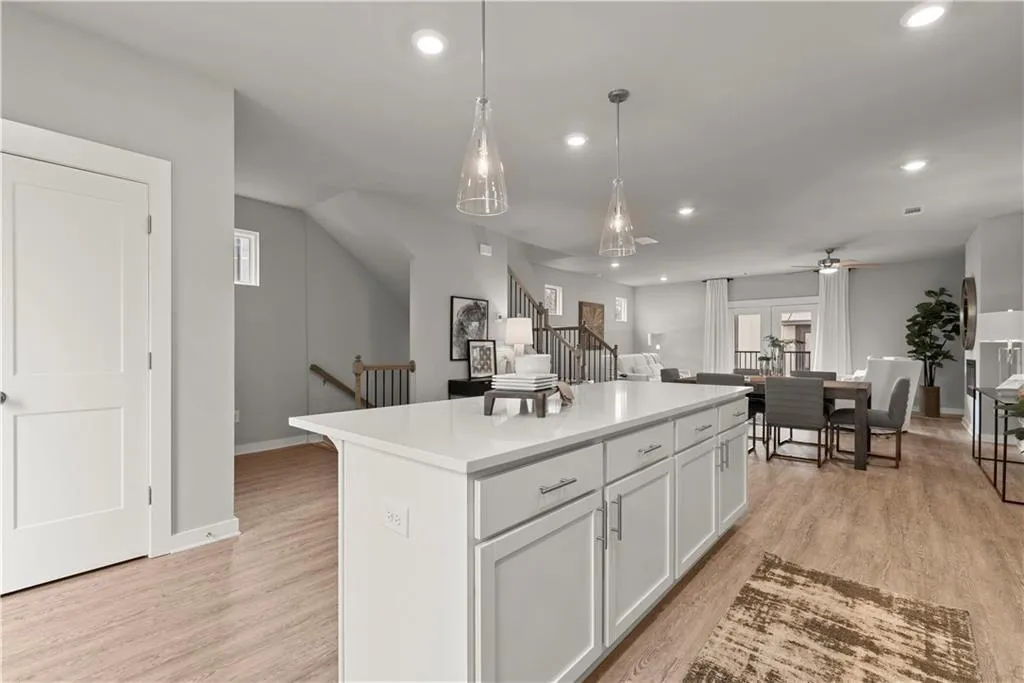 Kitchen featuring white cabinetry, light wood finished floors, open floor plan, decorative light fixtures, and recessed lighting