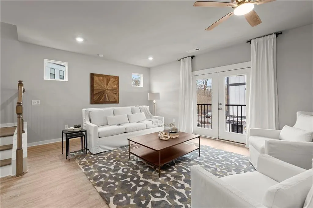 Living room with plenty of natural light, french doors, light wood-style flooring, and recessed lighting