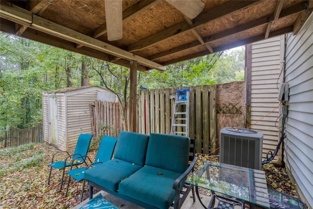 View of patio / terrace featuring an outdoor living space, a storage unit, and central AC