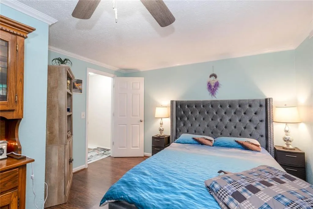 Bedroom featuring ceiling fan, ornamental molding, a  and dark hardwood / wood-style flooring