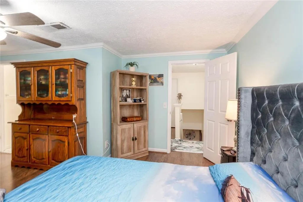 Bedroom with a ceiling fan, crown molding, and dark hardwood / wood-style flooring