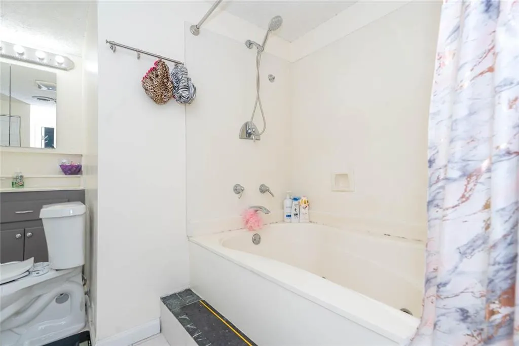 Full bathroom featuring vanity, toilet, and shower / tub combo with curtain