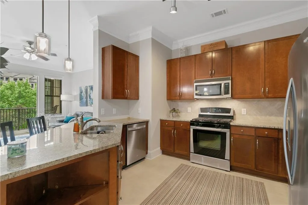 Large kitchen has gas cooking, stainless appliances, large pantry with breakfast bar and stone countertops