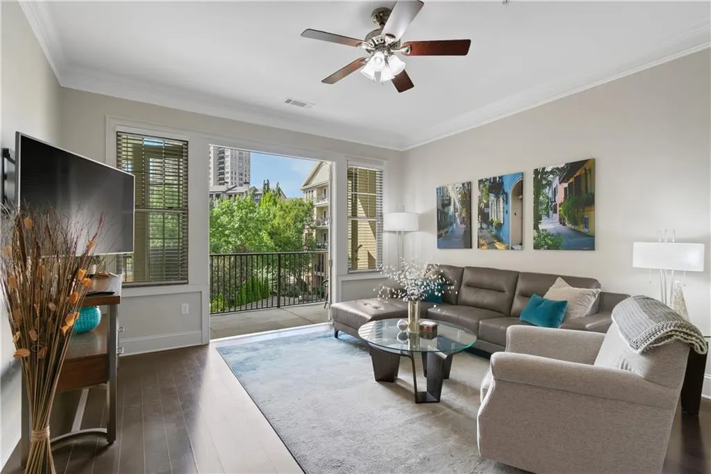 Bright living room overlooking pool with 10 foot ceilings, crown molding and hardwood floors