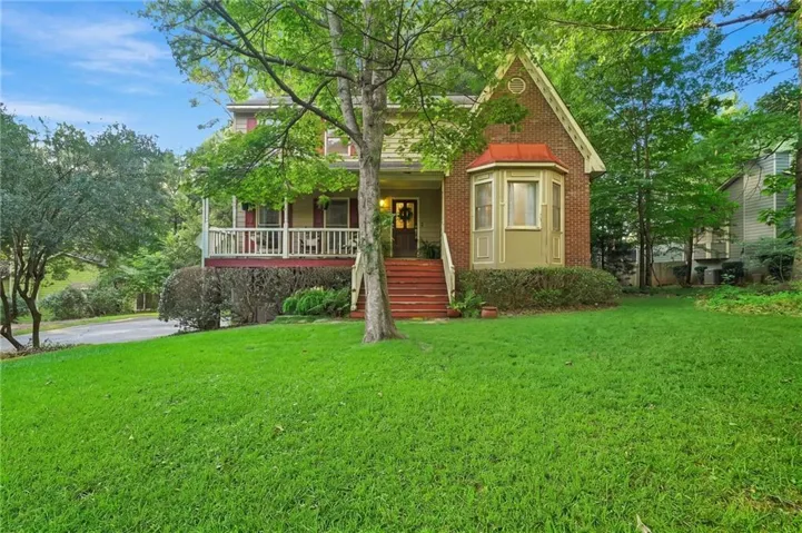 Charming home featuring a classic brick and wood-sided exterior with a welcoming front porch and white railings