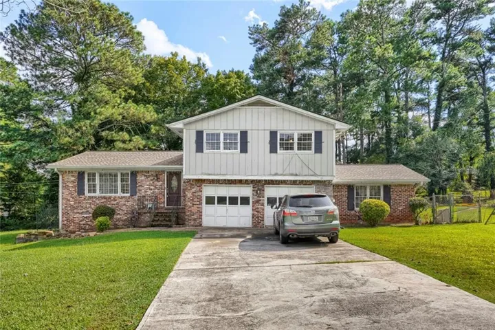 Split-level exterior featuring brick and vertical siding