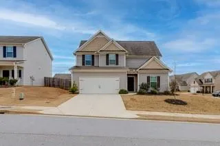 View of front of house with an attached garage and concrete driveway