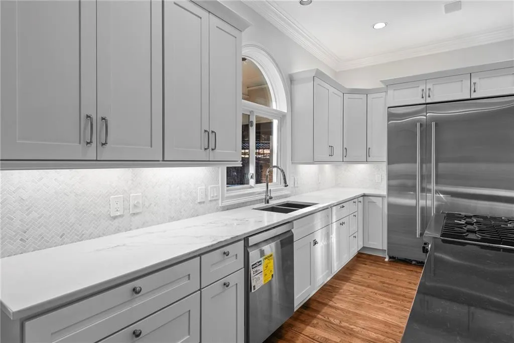 Beautiful stone  counter tops, tile backsplash. Arched window overlooks back yard.