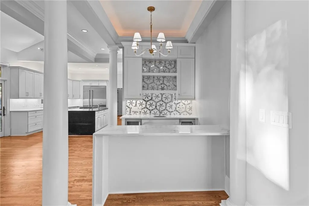 Wet bar has two beverage chillers, new cabinetry, stone countertops & backsplash tile