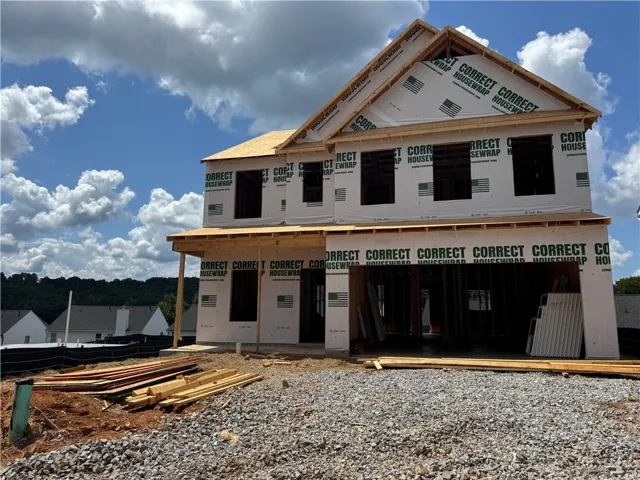 Two-story residential structure under construction with a gabled roofline