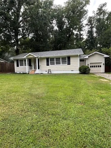 Single-story residence with a covered front entry, attached garage, and a fenced side yard