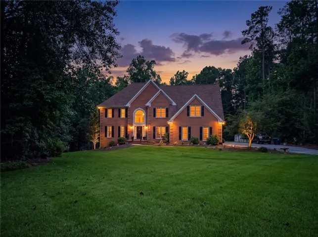 Brick exterior with gabled roof lines and a prominent arched window above the entry