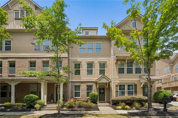 Three-story townhome with a combination of brick and siding facade