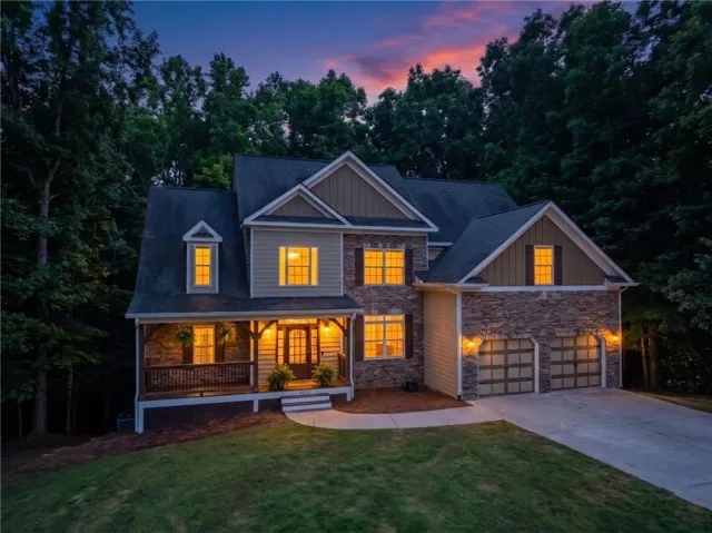 Two-story home featuring a stone and siding exterior with a covered front porch