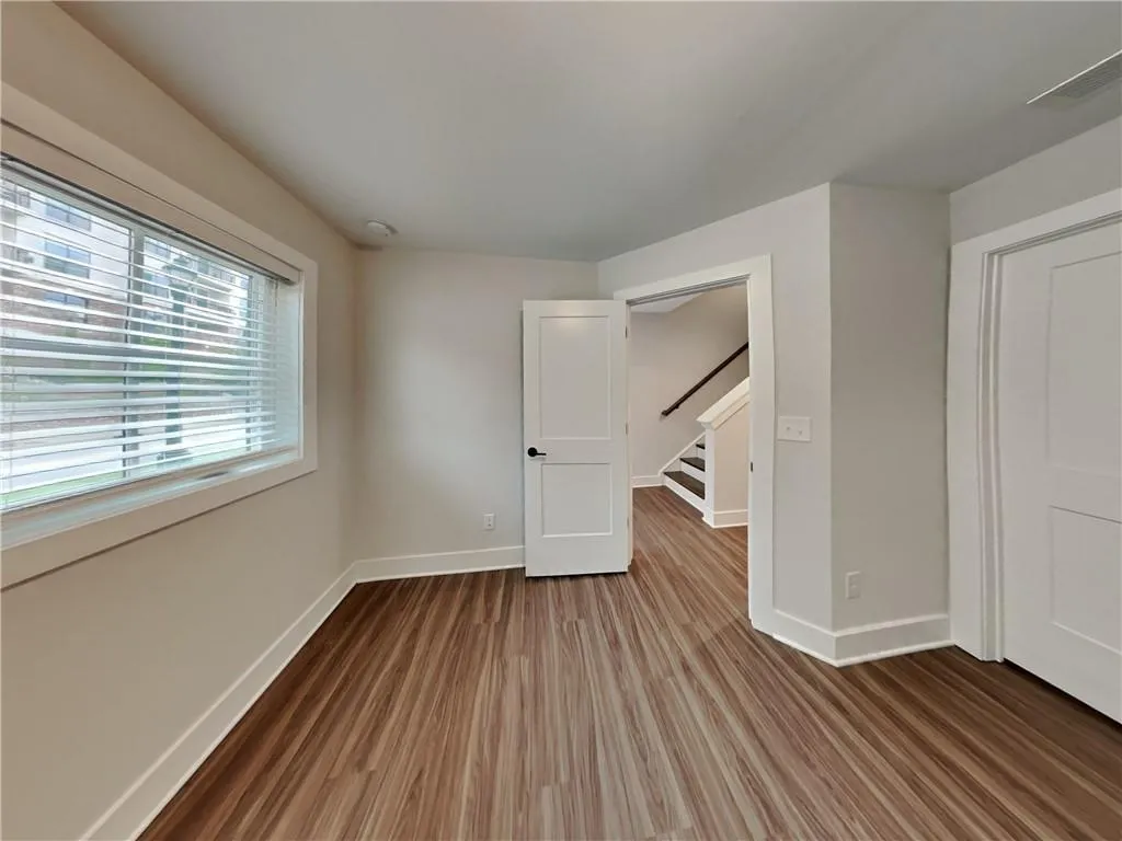 Unfurnished bedroom featuring dark wood-style floors and baseboards