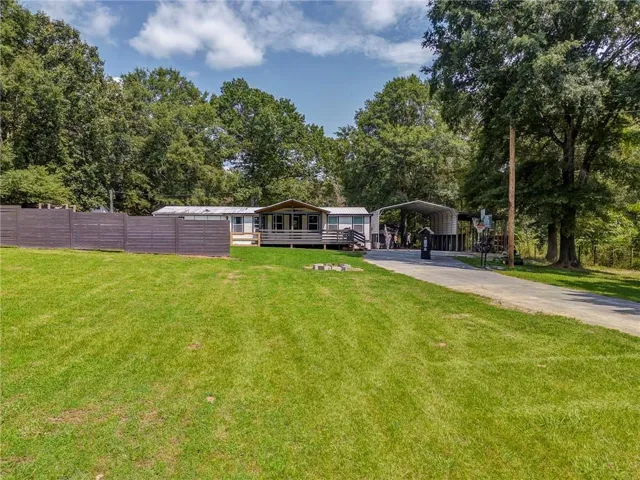 Extensive green lawn with a paved driveway and mature trees