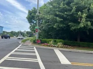 View of asphalt road featuring traffic signs and curbs