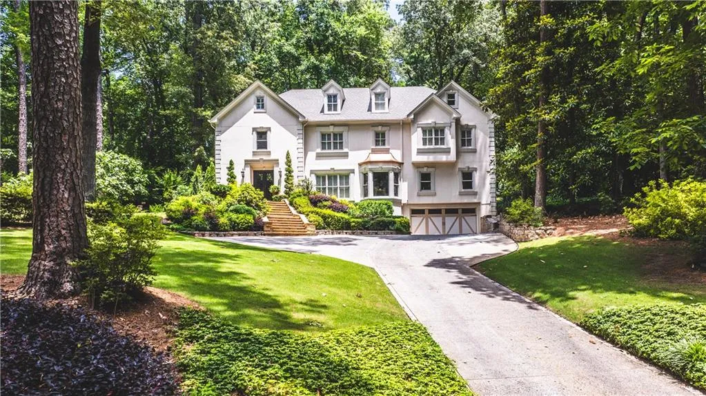 View of front of house featuring an attached garage, stairs, asphalt driveway, and a front yard