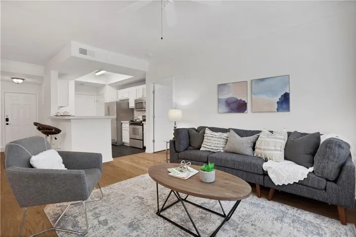 Recessed lighting, wood-finish flooring, white paneled door, ceiling fan, and a kitchen pass-through