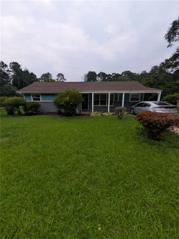 Charming single-story residence with a sprawling manicured lawn, mature landscaping, and established trees