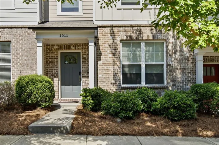 Brick facade with contrasting siding, covered front entry, and a paneled front door with a glass insert