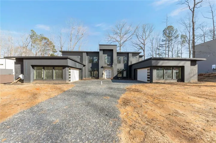 Contemporary home featuring driveway, a garage, and stucco siding