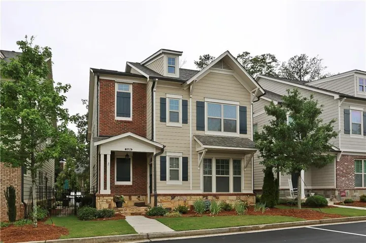 Two-story exterior with brick and siding facade, covered front entry, dormer window, and stone accents *photo from previous listing*