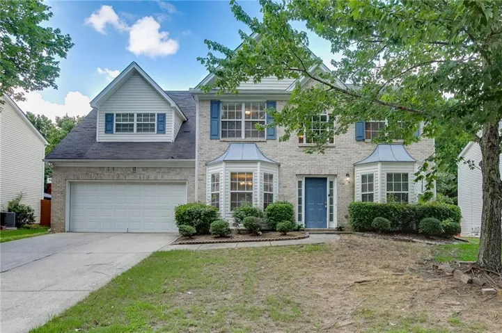 Beautiful two-story brick-front home with mature landscaping, bay windows, and a spacious two-car garage.