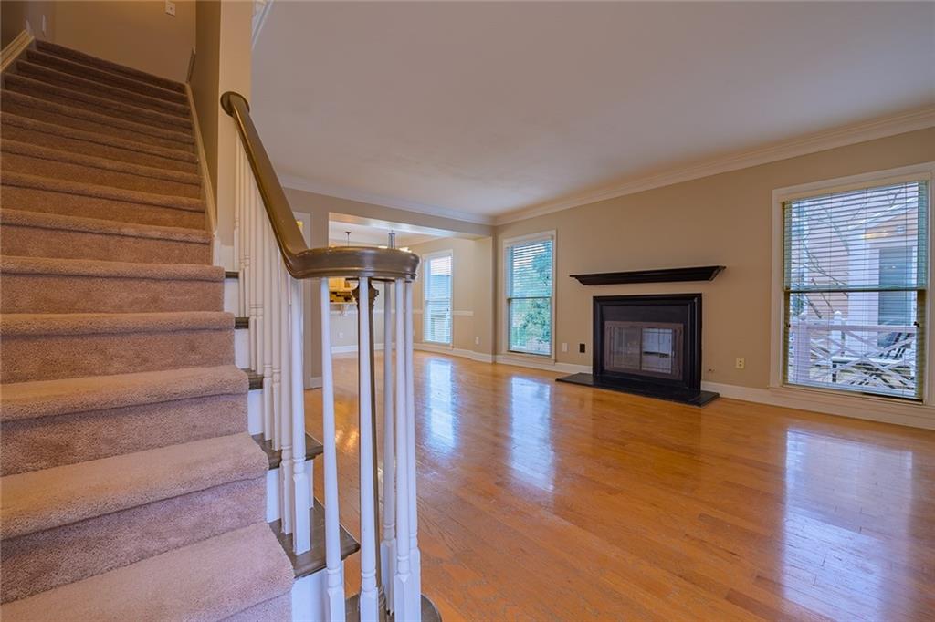 Staircase featuring crown molding and light hardwood / wood-style flooring