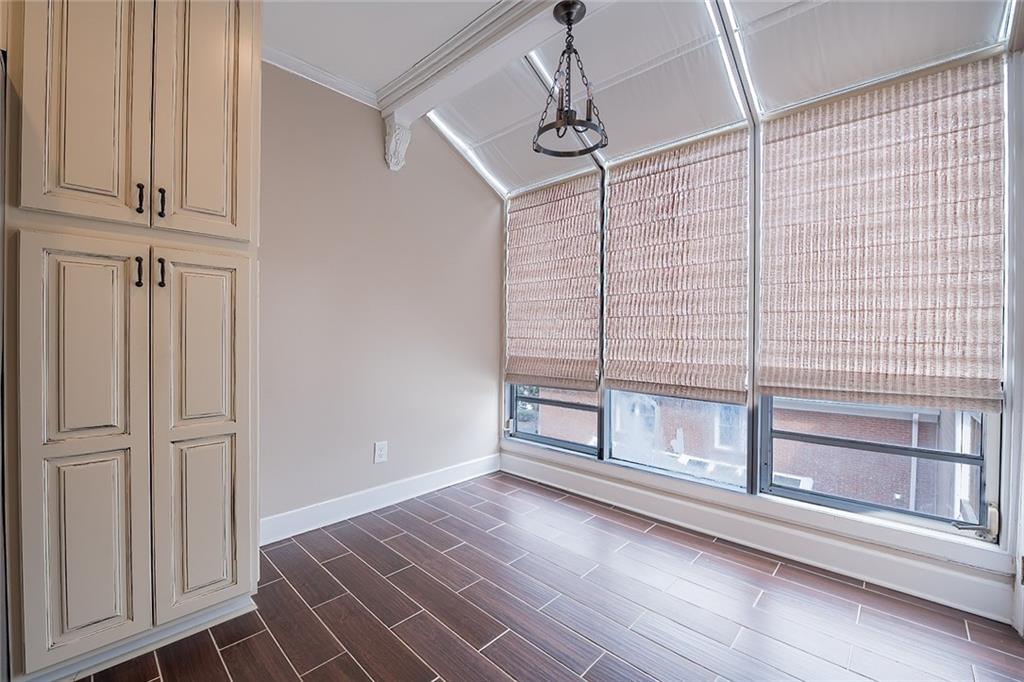 Spare room with vaulted ceiling with beams, crown molding, and dark wood-type flooring